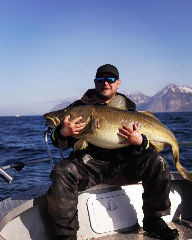 Mann som holder fisk fanget på fjorden