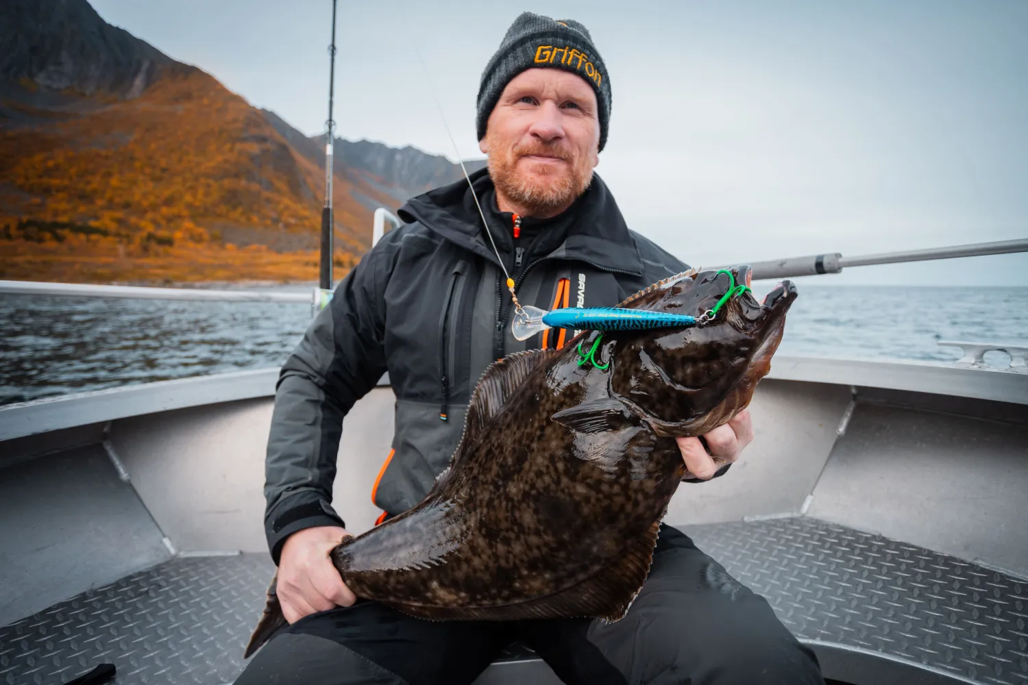 Mann som holder fisk fanget på fjorden