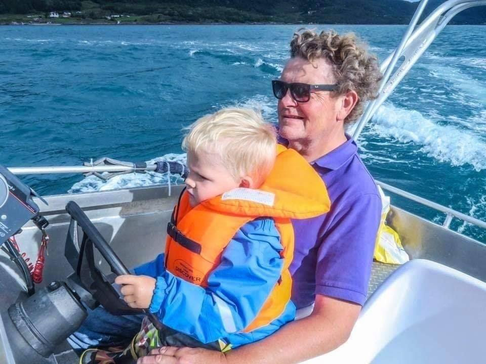 Mann og barn kjører båt